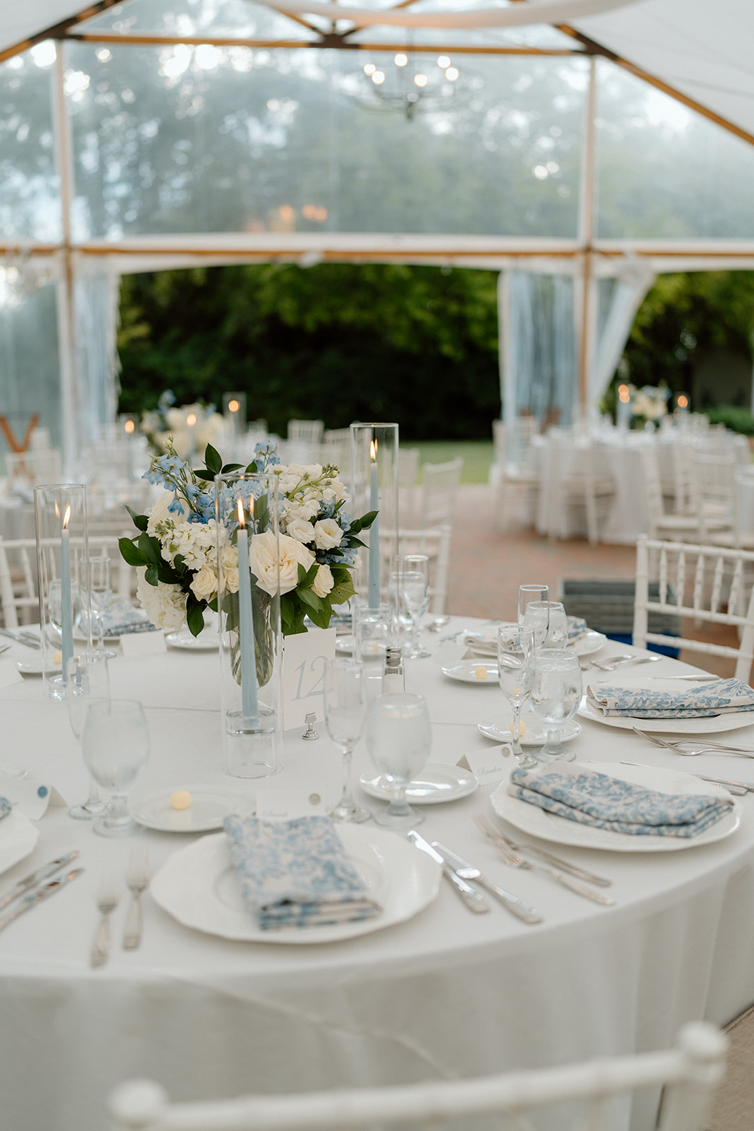 Blue and white event tablescape under an elegant tent